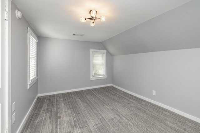 additional living space with carpet floors, lofted ceiling, visible vents, and baseboards