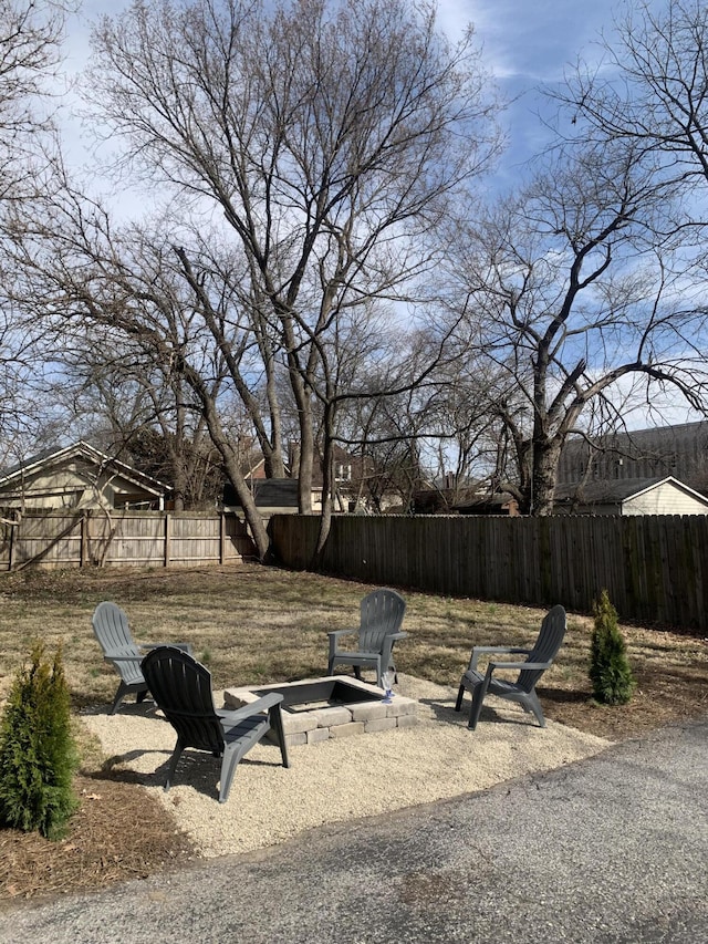 view of yard with fence and an outdoor fire pit