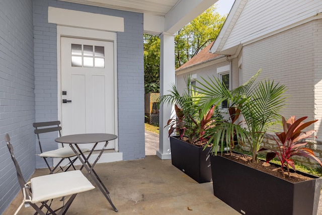 entrance to property featuring a patio area and brick siding