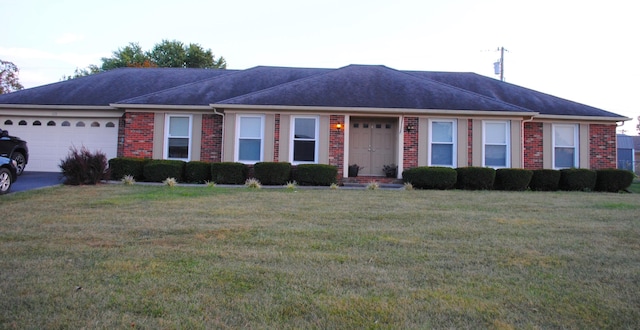 ranch-style house featuring a garage and a front lawn