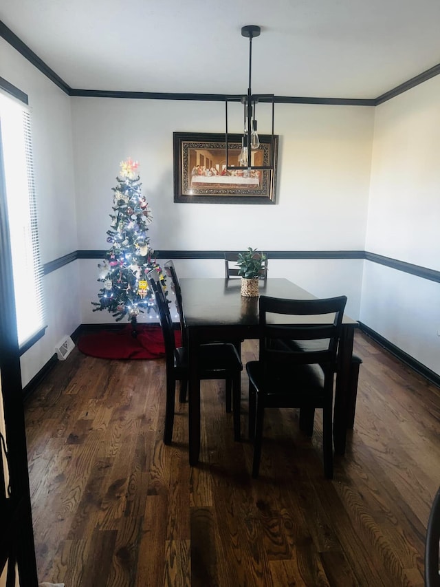 dining space with crown molding and dark hardwood / wood-style floors