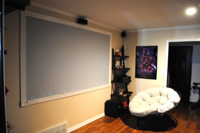 living area with hardwood / wood-style floors and ornamental molding