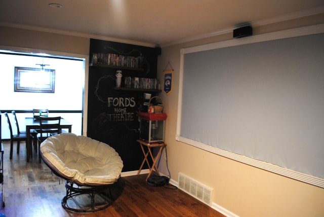 sitting room with crown molding and wood-type flooring