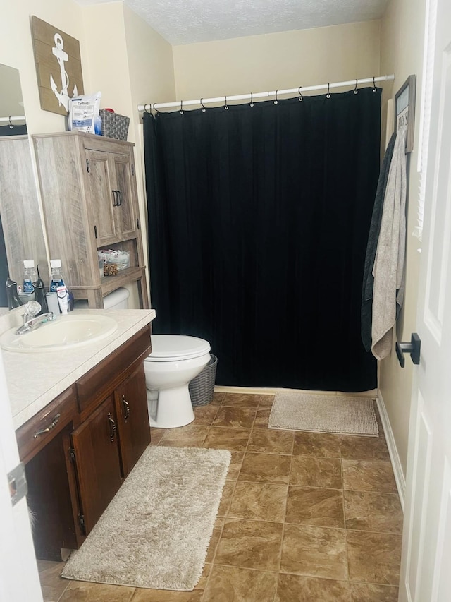 bathroom with vanity, a textured ceiling, and toilet