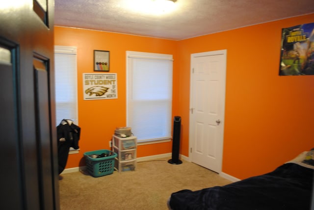 bedroom featuring a textured ceiling and light colored carpet