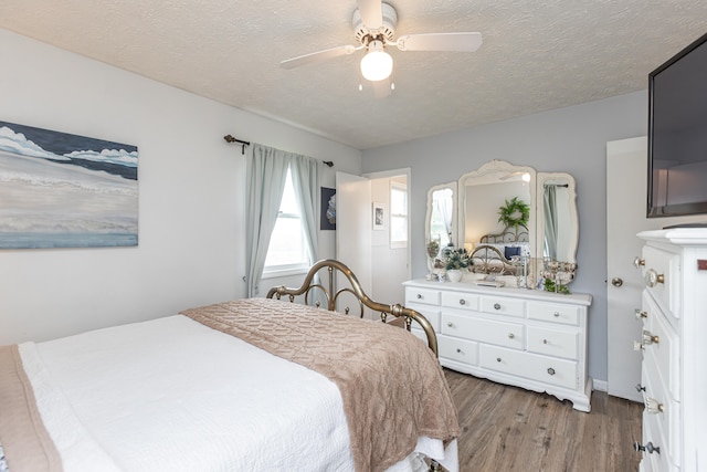 bedroom featuring a textured ceiling, wood-type flooring, and ceiling fan