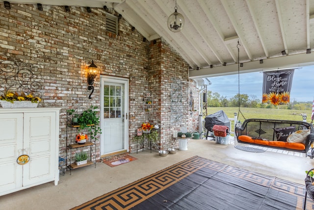 unfurnished sunroom with lofted ceiling with beams and a healthy amount of sunlight