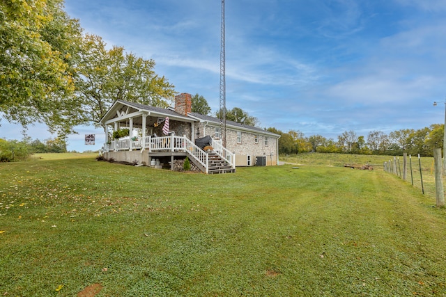 rear view of property featuring a yard and a wooden deck