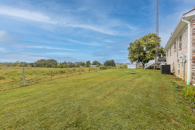 view of yard featuring a shed, central air condition unit, and a rural view