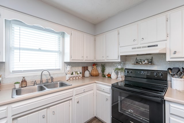 kitchen with range hood, electric range, sink, and white cabinets