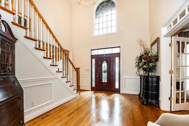 foyer featuring a wealth of natural light, wood-type flooring, and a high ceiling