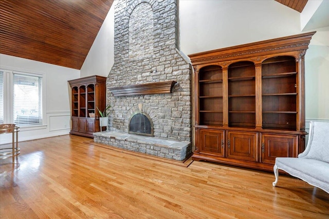 unfurnished living room with high vaulted ceiling, light hardwood / wood-style floors, and a fireplace