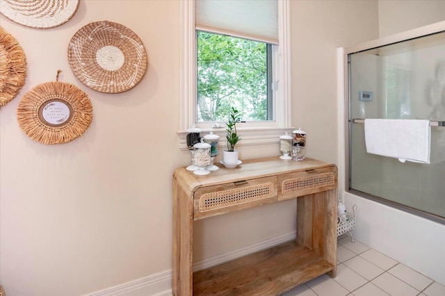 bathroom with tile patterned flooring and combined bath / shower with glass door