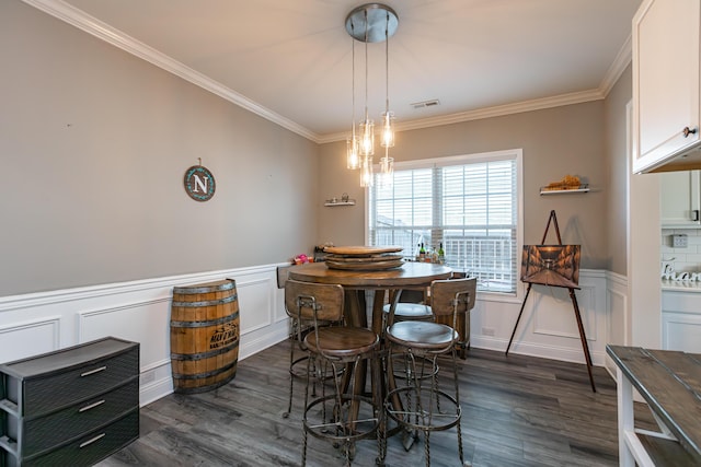 dining space featuring crown molding and dark wood-type flooring