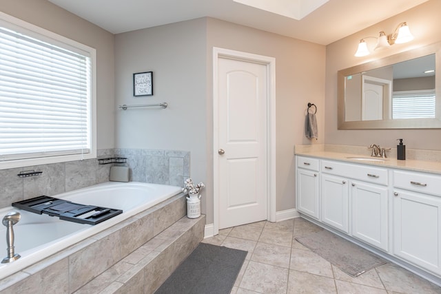 bathroom featuring tile patterned floors, vanity, a healthy amount of sunlight, and a relaxing tiled tub