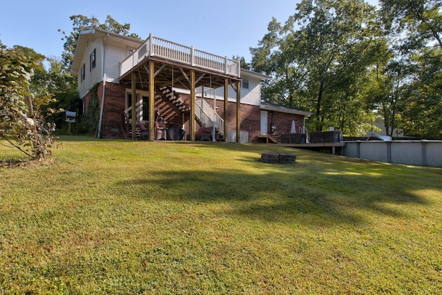 rear view of house with a yard and a wooden deck