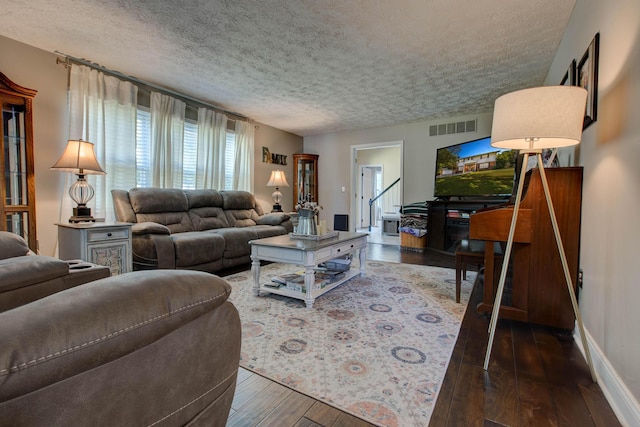 living room with dark wood-type flooring and a textured ceiling