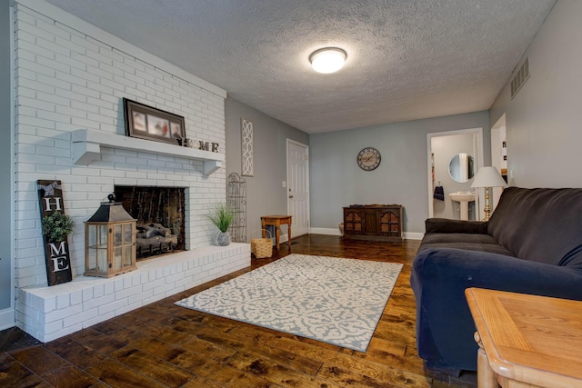 living room with a fireplace, dark wood-type flooring, and a textured ceiling