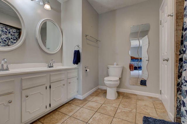 bathroom featuring vanity, a textured ceiling, toilet, and tile patterned floors