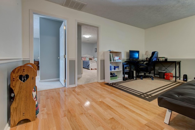 office area with a textured ceiling and wood-type flooring