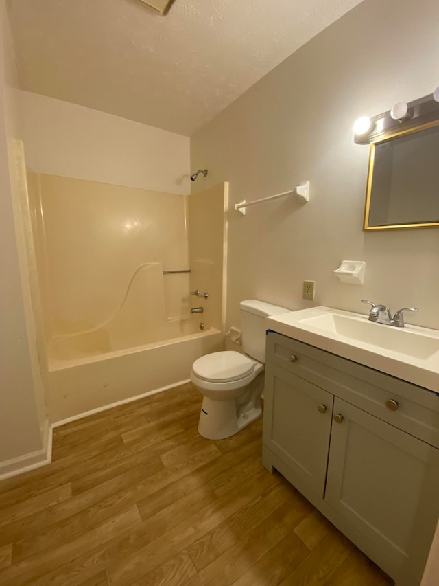 full bathroom featuring vanity, hardwood / wood-style floors, shower / tub combination, and toilet