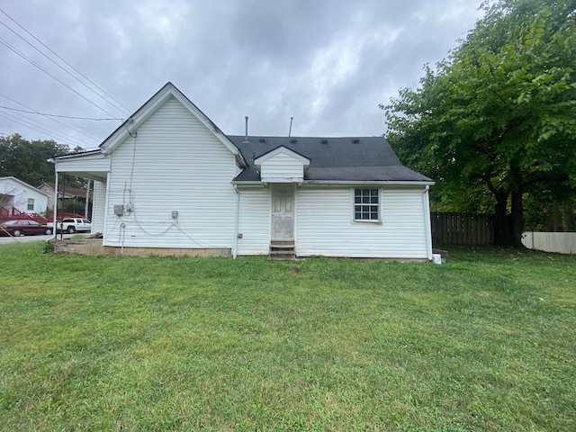 rear view of house featuring a yard