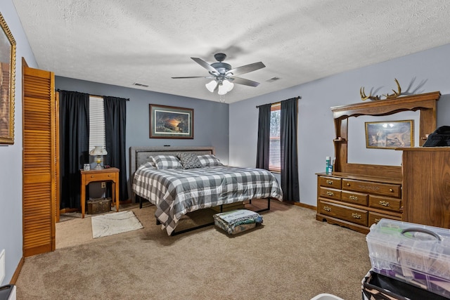 bedroom featuring ceiling fan, a textured ceiling, and carpet floors