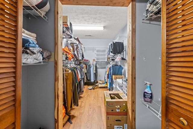 walk in closet with wood-type flooring