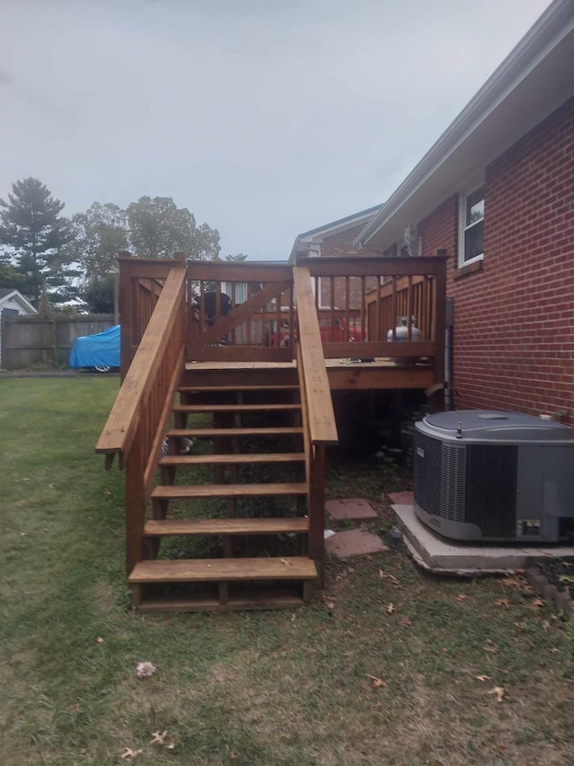 wooden deck with central air condition unit and a yard