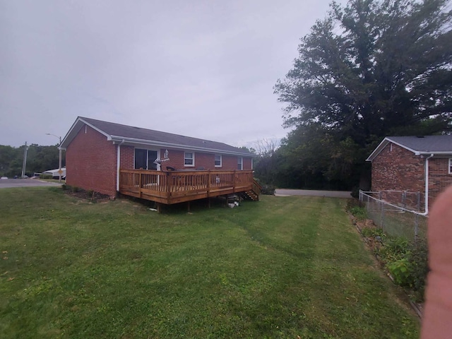 rear view of property with a yard and a deck