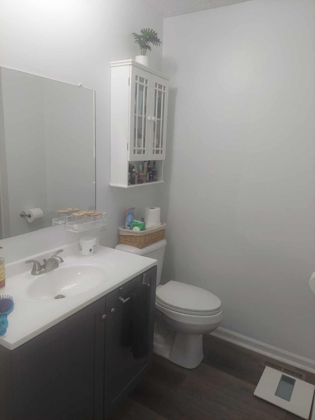 bathroom featuring hardwood / wood-style floors, vanity, and toilet