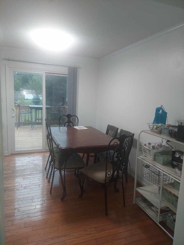 dining space featuring crown molding and hardwood / wood-style floors