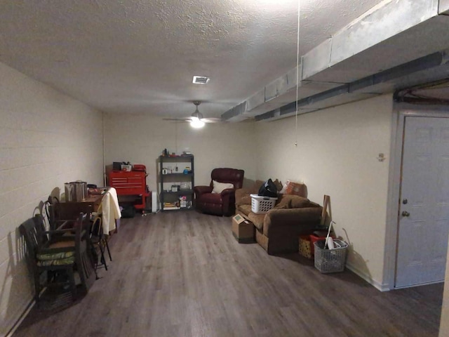 basement with ceiling fan, a textured ceiling, and hardwood / wood-style flooring