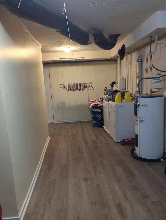 basement with washer and dryer, a textured ceiling, dark hardwood / wood-style flooring, and water heater