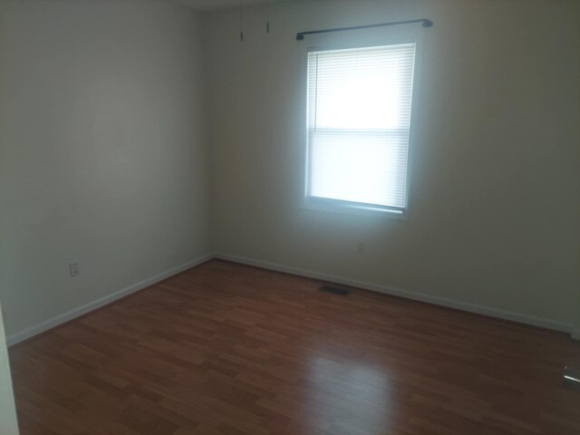 spare room featuring dark wood-type flooring