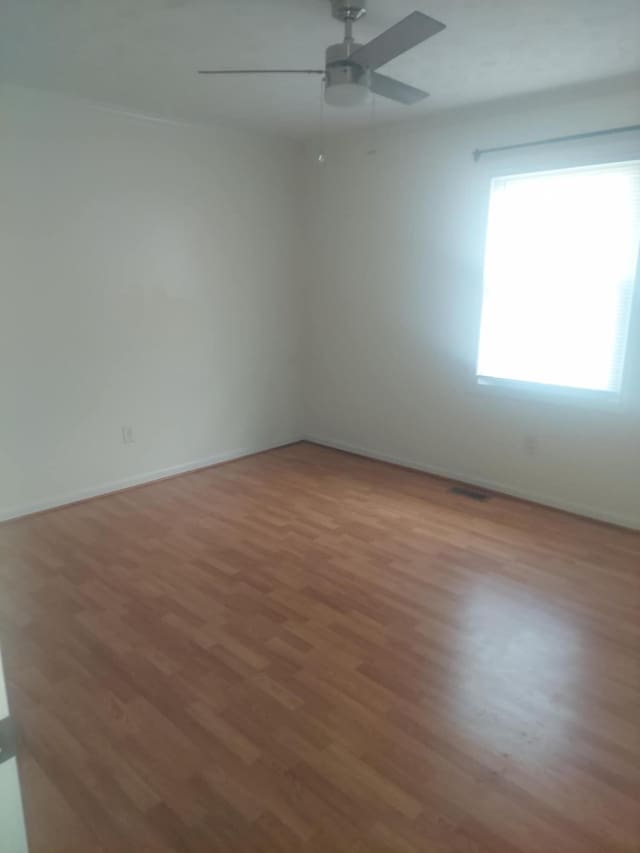 empty room with hardwood / wood-style flooring and ceiling fan