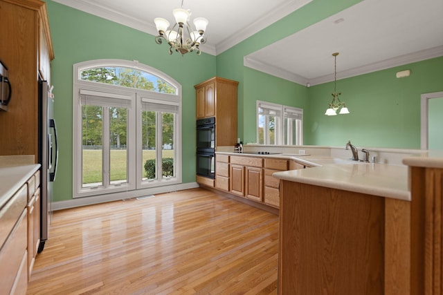 kitchen with an inviting chandelier, sink, pendant lighting, and crown molding