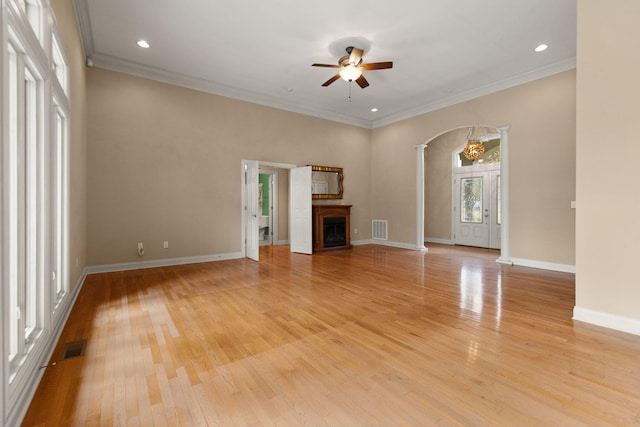 unfurnished living room with plenty of natural light, ornamental molding, light hardwood / wood-style floors, and ornate columns