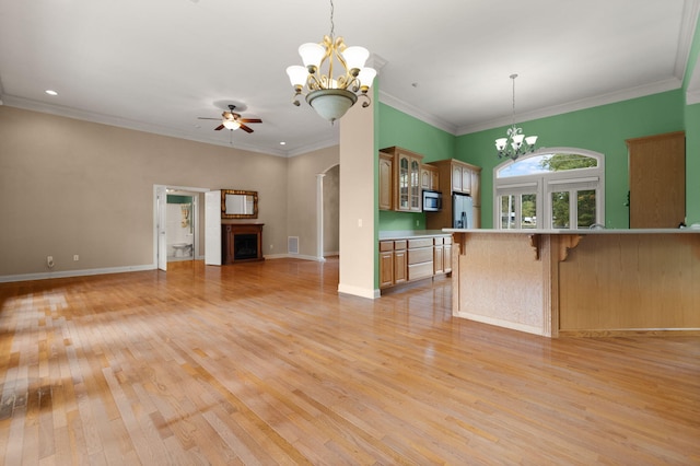 kitchen featuring stainless steel appliances, crown molding, pendant lighting, and a breakfast bar area