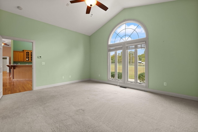 unfurnished living room featuring plenty of natural light, light carpet, lofted ceiling, and ceiling fan