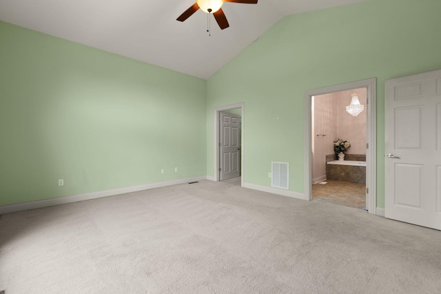 unfurnished bedroom with ensuite bathroom, high vaulted ceiling, light carpet, and ceiling fan