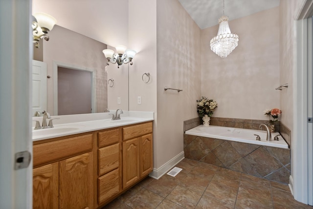 bathroom with vanity, a relaxing tiled tub, and a chandelier