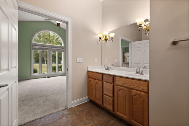 bathroom with vanity, vaulted ceiling, and a notable chandelier