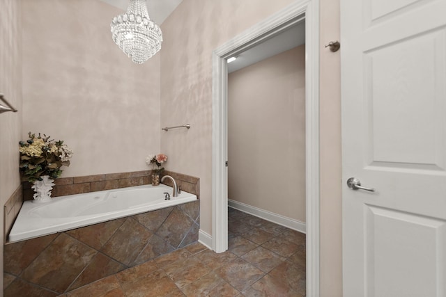 bathroom with tiled bath and an inviting chandelier