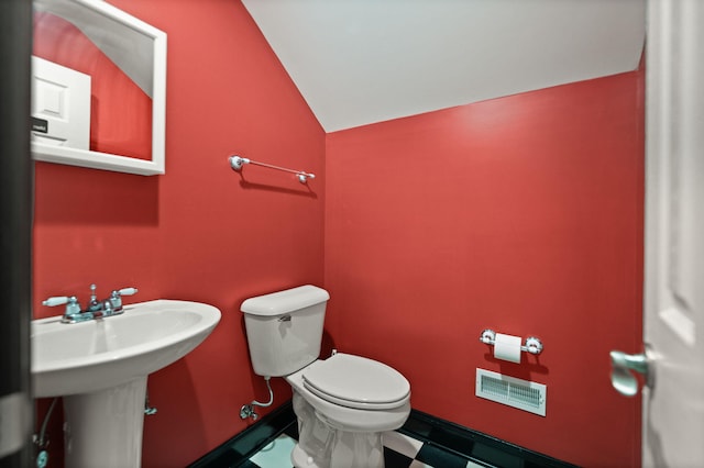 bathroom with lofted ceiling and toilet