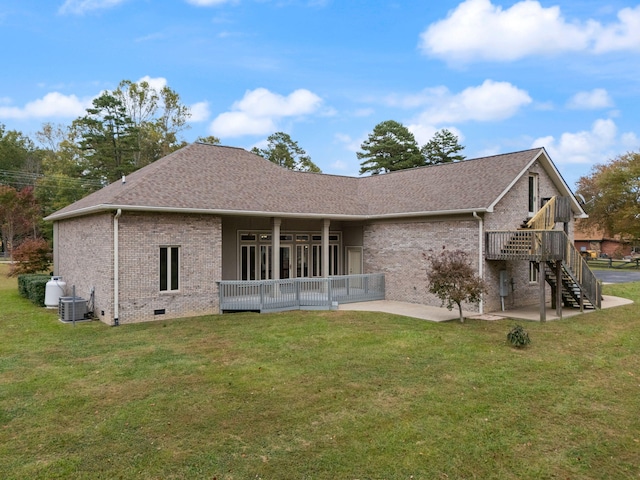 back of property with a lawn, central AC unit, and a patio area