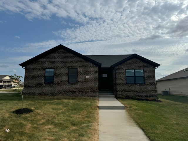 view of front of home with a front lawn and central AC unit