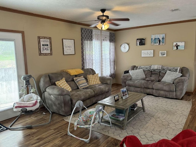 living room featuring plenty of natural light, wood finished floors, and ornamental molding