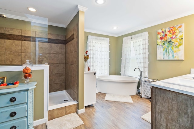 bathroom with hardwood / wood-style floors, independent shower and bath, ornamental molding, and vanity