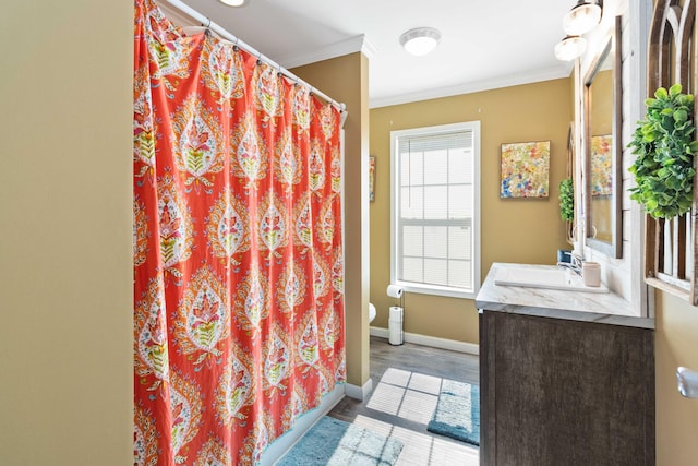 bathroom with toilet, hardwood / wood-style floors, walk in shower, crown molding, and vanity